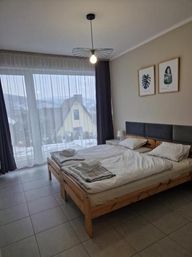 米德尔布罗齐齐耶维奇Domki Piecykowo的一间卧室设有一张大床和一个大窗户