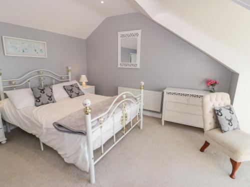 巴茅思Ceilwart Cottage的卧室配有白色的床和椅子