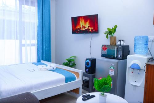 KiambuKimsy Studio的卧室配有一张床,墙上配有电视。