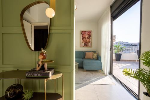 特拉维夫YalaRent Flora- Designed 1BR penthouse in Florentin的客厅设有绿色的墙壁和镜子