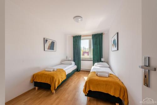 科沃布热格Horyzont Apartamenty -Domek na Sosnowej z tarasem的一间卧室设有两张床和窗户。