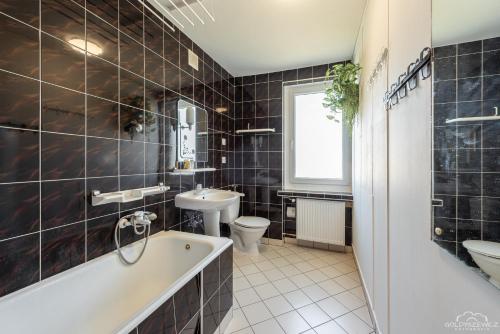 科沃布热格Horyzont Apartamenty -Domek na Sosnowej z tarasem的带浴缸、盥洗盆和卫生间的浴室