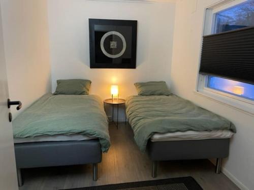 灵塞德House with garage in central Lyngen的一间卧室设有两张床、一个窗口和一盏灯。