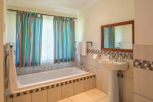 维多利亚瀑布Batonka Guest Lodge的带浴缸和盥洗盆的浴室