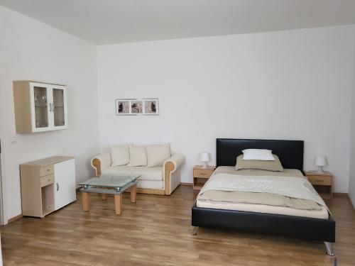 汉堡奈斯特汉堡宁多夫酒店的一间卧室配有一张床、一张沙发和一张桌子