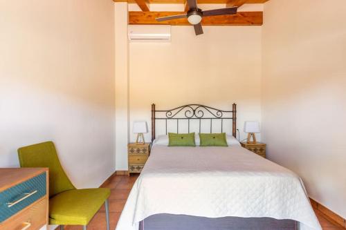 Casa rural LA PEDANIA的一间卧室配有一张床和一把绿色椅子