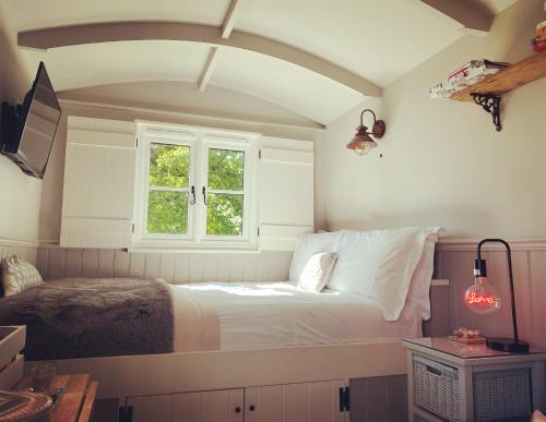 门蒂斯港Poachers Hut at Keepers Cottage - Hot Tub & Pizza Oven - Trossachs的一间卧室设有一张床和一个窗口