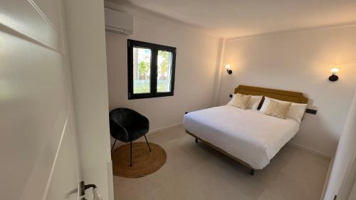 帕格拉Casa Goldberg的一间卧室设有一张床、一个窗口和一把椅子