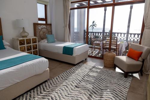 蒙巴萨Sultan Palace Beach Retreat Mombasa的一间带两张床的卧室和一间带阳台的客厅