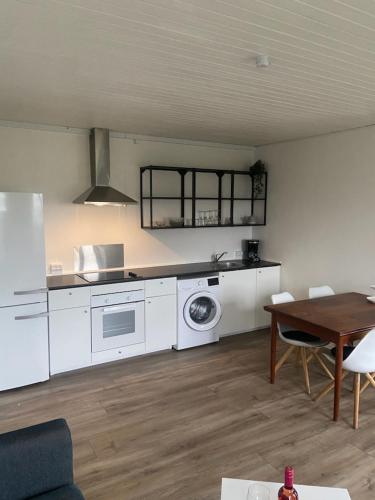 灵斯泰兹VV Apartments 50,1的一间厨房,配有白色家电和桌椅