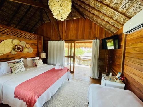 卡姆布库Pousada Casa Caju Bangalows的一间卧室配有两张床和吊灯。