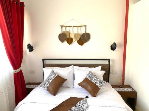 赫尔格达New cozy apt. on the promenade的卧室配有白色的床和红色窗帘