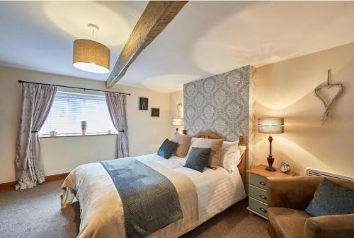 布拉夫Cosy Cumbrian cottage for your country escape的一间卧室配有一张大床和一张沙发