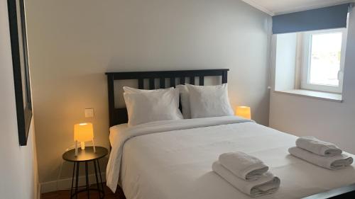 里斯本SORIANO Place的卧室配有带毛巾的大型白色床
