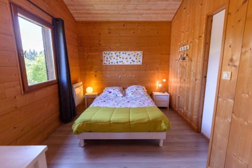 Arzens耐图内伍德旅馆的木制客房内的一间卧室,配有一张床