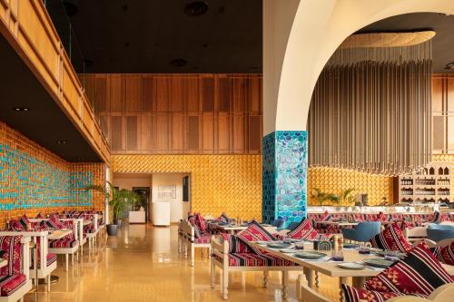 吉达SHIRVAN Hotel City Yard Jeddah的用餐室设有桌椅和黄色的墙壁