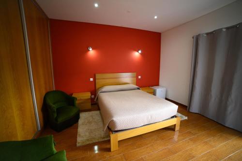 阿马里什Funileiro, apartamentos e quartos的一间卧室配有一张床和一把绿色椅子