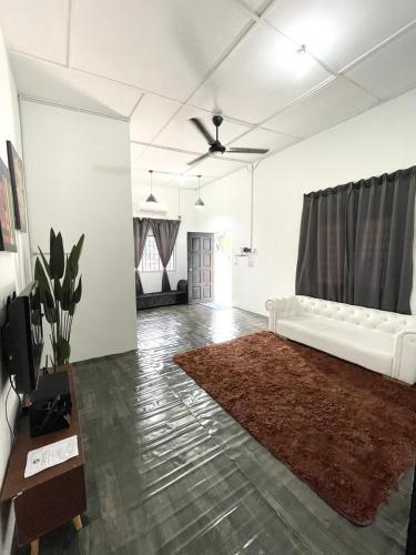 瓜拉立卑Eager Homestay的客厅配有白色沙发和地毯。