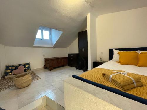 依诺罗达Sea View Loft的一间卧室配有一张带黄色枕头的床和一扇窗户
