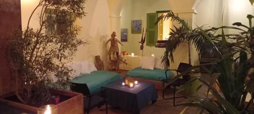 格雷岛La Maison du Marin的一间设有两张床、桌子和植物的房间