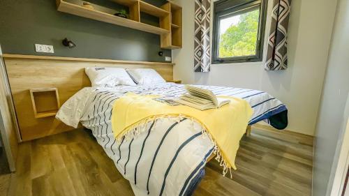 普卢加斯努梅斯克奥露营地的一间卧室配有一张黄色和蓝色毯子的床