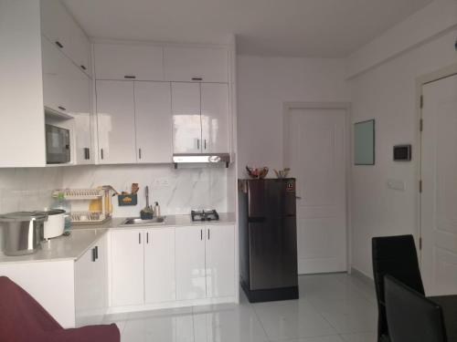 马累Resting View的厨房配有白色橱柜和黑色冰箱。