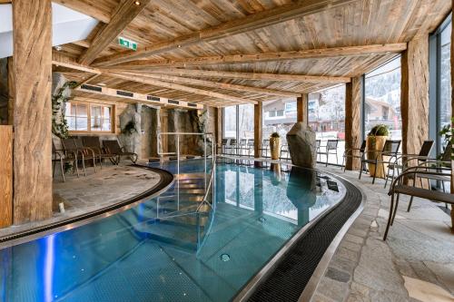 瑟尔赫克斯那姆餐厅酒店的一座带木制天花板的建筑中的游泳池
