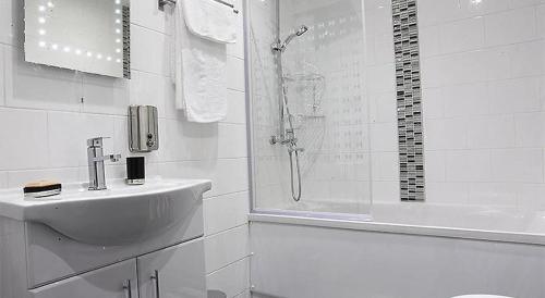 曼彻斯特Apartment in the Heart of the Northern Quarter的白色的浴室设有水槽和淋浴。