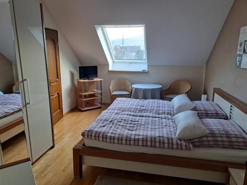 策尔廷根-拉蒂希Pension Birgit Pazen的一间卧室设有两张床、一张桌子和一个窗口
