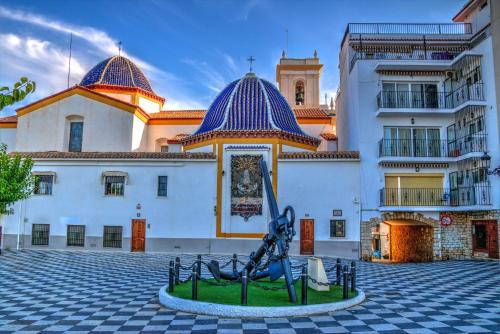 贝尼多姆Benidorm Center Puerto Poniente 1º的一座大建筑,前面有雕像