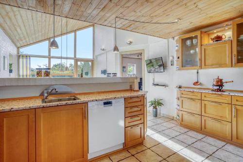 比伦德Casa Fyrrevænget的厨房配有木制橱柜和白色洗碗机。