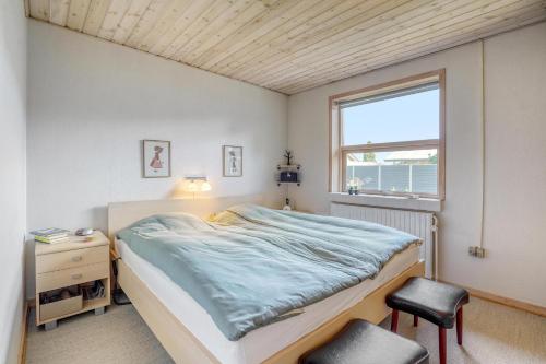 比伦德Casa Fyrrevænget的一间卧室设有一张床、一个窗口和一把椅子