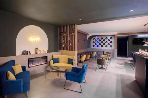 特拉诺瓦-布拉乔利尼Moody smart & comfy Hotel的大堂设有蓝色椅子和壁炉