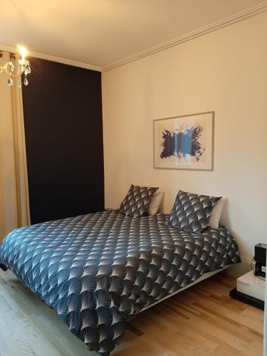 勒米尔蒙La chambre de maître du boulevard Thiers, entrée et terrasse privatives的一间卧室配有一张带蓝色棉被的床