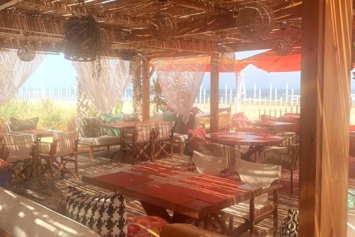 布兹尼盖Appartement Bahia Golf Beach的餐厅设有桌椅和大窗户。