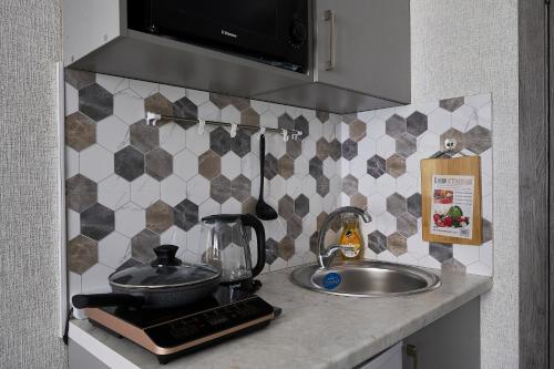 阿拉木图Апарт 33的厨房柜台设有水槽和搅拌机