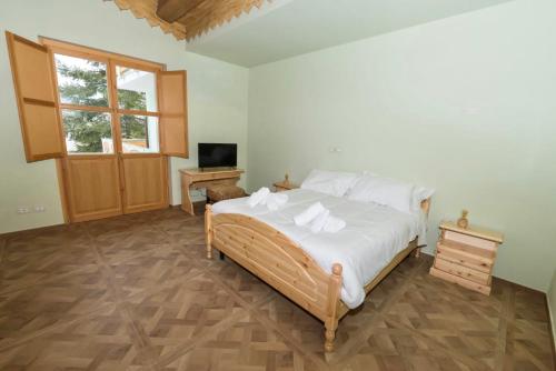 阿塞尔吉La Valle del Gran Sasso的一间卧室配有一张带白色床单的床和电视。