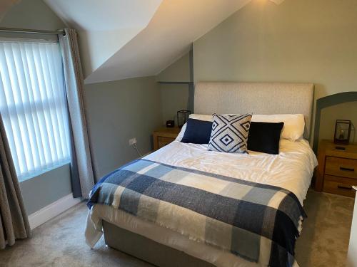 贝尔法斯特Victorian South Belfast area Lisburn Road 3 Double Bedrooms - Great Transport Links的卧室配有带枕头的床铺和窗户。