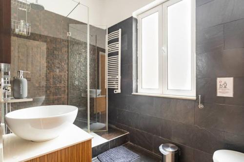 里斯本Guest House Bairro Azul的一间带水槽和玻璃淋浴的浴室