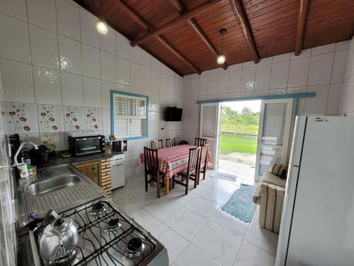 拉古纳Casa temporada praia da galheta 3的厨房配有冰箱和桌椅