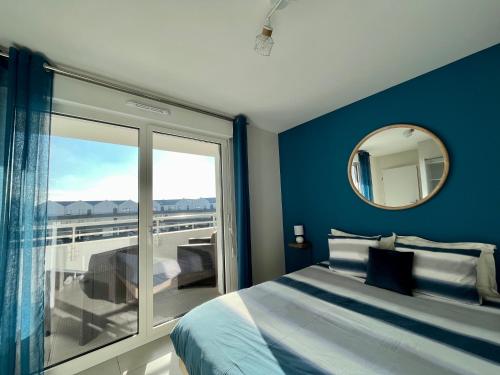 敦刻尔克L'intemporel plage - Malo'Cation的一间带床和镜子的卧室以及一个阳台