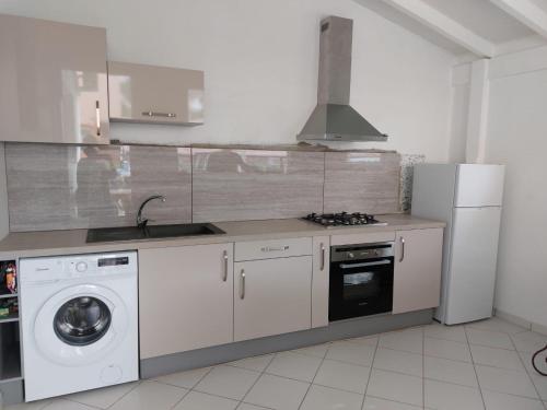 莱昂斯-达赫雷T2 cirique的厨房配有洗衣机和冰箱。