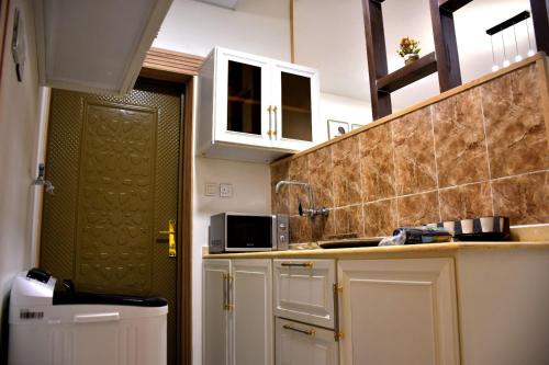 奈季兰فندق الجوافة的厨房配有白色橱柜和绿门
