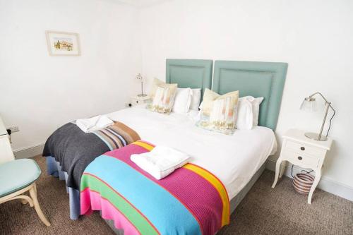 考斯Paskins, Cowes - Sleeps 4 - 2 Bed - 2 Bath - Central Location的一间卧室配有两张床和一张带台灯的桌子