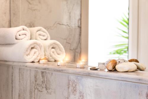 波利克罗诺Villa Pearl的浴室柜台配有毛巾和蜡烛