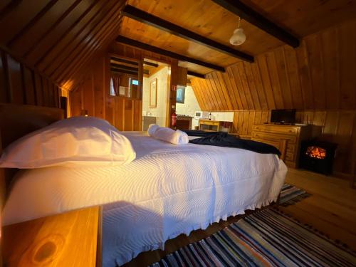 桑塔纳Abrigo da Serra- Nature Trails的卧室配有一张带白色床单和枕头的大床。