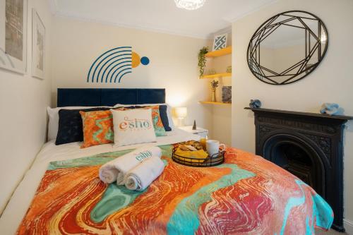 赛伦塞斯特Spacious home with garden Heart of the town WiFi Smart TV的一间卧室配有一张带毛巾的床和壁炉