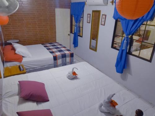 莱昂Hostal Leyendas的一间卧室配有两张带蓝色窗帘和镜子的床。