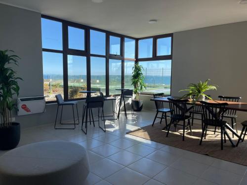 蒙特港Puerto Montt apartamento en playa Pelluco的用餐室设有桌椅和窗户。