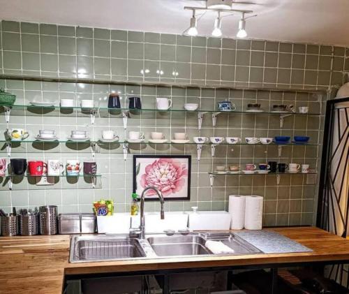 曼谷Big Groups Heaven in Central Location的厨房设有水槽和绿色瓷砖墙。